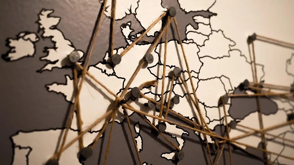 A map of Europe with a network of pins and strings connecting various locations.